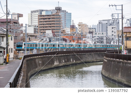 [Keihin-Tohoku Line] A local train passing through the streets of Kamata in the early morning. 139387792