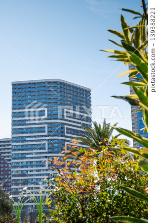 Modern high-rise residential buildings with glass facades against a clear blue sky Modern high-rise residential buildings with glass facades against a clear blue sky 139388221