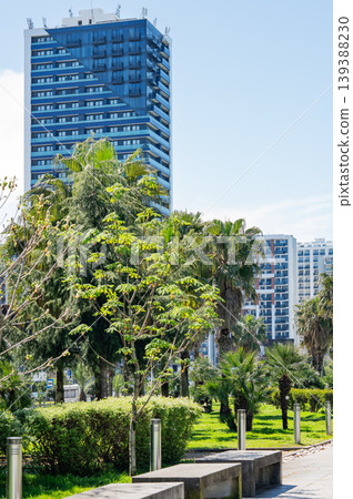 A green city park with trees and modern residential buildings in the background. A green city park with trees and modern residential buildings in the background. 139388230