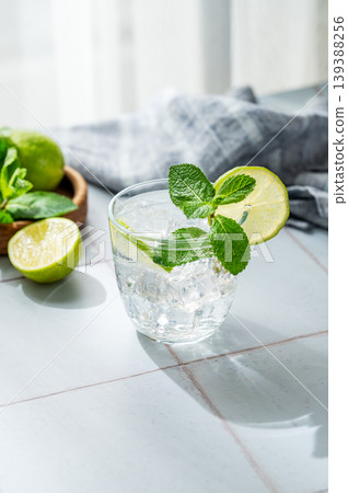 A fresh mojito with lime, mint and ice in glass. Citrus lemonade or cocktail on a table 139388256