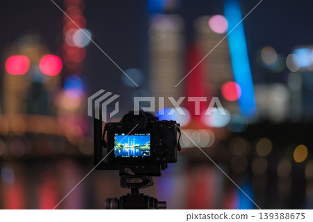 相機液晶螢幕上顯示了上海的夜景和色彩繽紛的散景背景。 相機液晶螢幕上顯示了上海的夜景和色彩繽紛的散景背景。 139388675