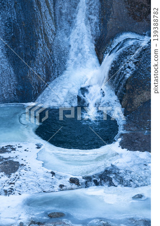Fukuroda Falls: A round waterfall basin and water cascading over frozen rocks (vertical composition, winter) Fukuroda Falls: A round waterfall basin and water cascading over frozen rocks (vertical composition, winter) 139388782