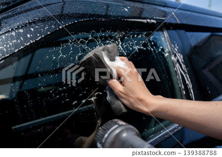 A man's hand washing a car A man's hand washing a car 139388788