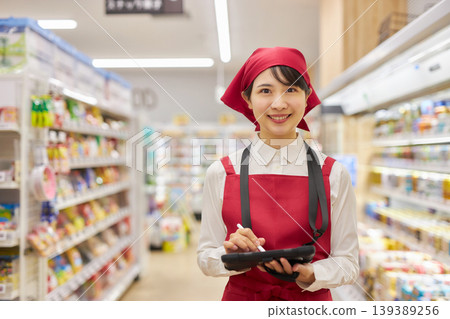 一位年輕女子正在使用平板電腦管理產品。 139389256