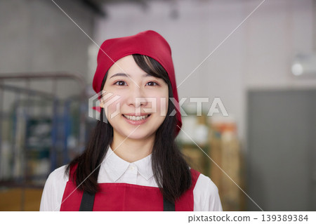 A young woman manages inventory using a tablet in the back room. A young woman manages inventory using a tablet in the back room. 139389384