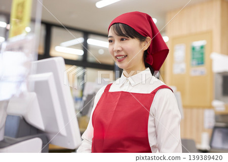 一位在超市收銀台工作的年輕女子 一位在超市收銀台工作的年輕女子 139389420