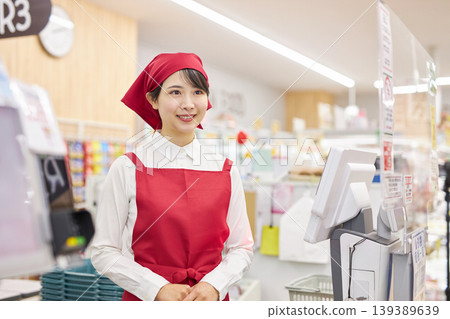 A young woman working at the checkout counter of a supermarket A young woman working at the checkout counter of a supermarket 139389639