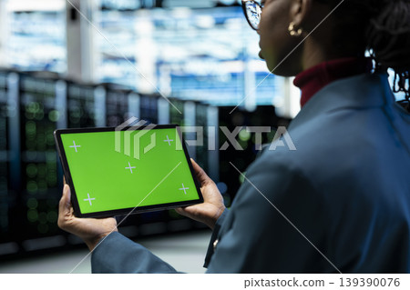 Green screen tablet in data center used by engineer evaluating hardware diagnostic reports. Server hub IT specialist using mockup device to automate supercomputers processing 139390076