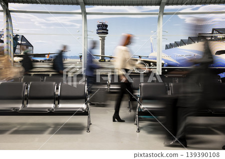 Blurry crowd in busy airport terminal waiting area traveling by plane, doing holiday trip. Silhouettes of travelers rushing to validate airplane tickets at departure gate for boarding Blurry crowd in busy airport terminal waiting area traveling by plane, doing holiday trip. Silhouettes of travelers rushing to validate airplane tickets at departure gate for boarding 139390108