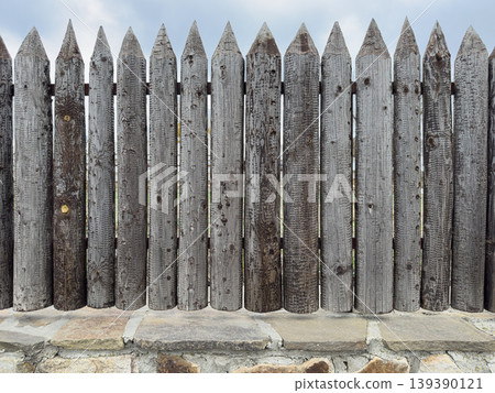 Wooden fence made of sharp pointed boards 139390121