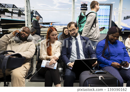 Businesswoman and colleague working on laptop in airport international transport hub waiting area. Businesspeople using notebook, brainstorming tasks in bright modern flight departure terminal Businesswoman and colleague working on laptop in airport international transport hub waiting area. Businesspeople using notebook, brainstorming tasks in bright modern flight departure terminal 139390162