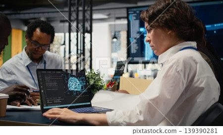 Programmers in office using specialized technology to accelerate complex AI calculations. IT workers managing neural network training datasets with notebook device, camera A 139390281