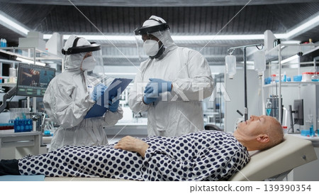 Healthcare professional in hazmat suit performs diagnostics on a patient infected with dangerous virus, studying immunity and vaccination response in a secure biocontainment environment. Camera A. Healthcare professional in hazmat suit performs diagnostics on a patient infected with dangerous virus, studying immunity and vaccination response in a secure biocontainment environment. Camera A. 139390354