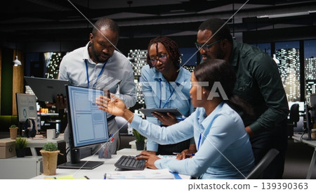 Black team of male consultants reviewing data analytics on desktop, building a vision and business strategy to accomplish objectives and success. Mindset for teamwork late at night. 139390363