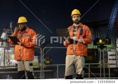 Technician on offshore platform using laptop to control subsea systems remotely at night. Specialist monitoring anomaly detection dashboard on notebook screen on drilling rig Technician on offshore platform using laptop to control subsea systems remotely at night. Specialist monitoring anomaly detection dashboard on notebook screen on drilling rig 139390604