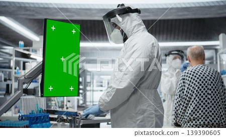 Vertical green screen next to black medic in hazmat suit observing contagious epidemic in lab, examining patient with serious symptoms. Preventing global disaster and health crisis. Camera A. Vertical green screen next to black medic in hazmat suit observing contagious epidemic in lab, examining patient with serious symptoms. Preventing global disaster and health crisis. Camera A. 139390605