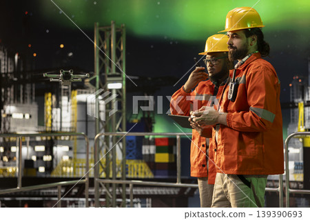 Drone tech used by offshore platform crew coworkers for aerial surveillance of maritime waters. Drilling ship teamworking colleagues monitoring oil spills with UAV during aurora borealis night Drone tech used by offshore platform crew coworkers for aerial surveillance of maritime waters. Drilling ship teamworking colleagues monitoring oil spills with UAV during aurora borealis night 139390693