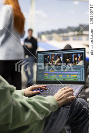 Young woman videographer working on video production in airport waiting area, editing footage and adding transitions for a cinematic film project. Location independent career and flexibility. 139390717