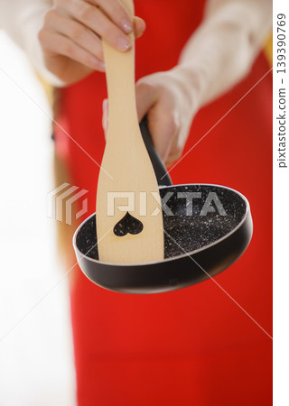 Woman hand holding cooking pan and spatula Woman hand holding cooking pan and spatula 139390769