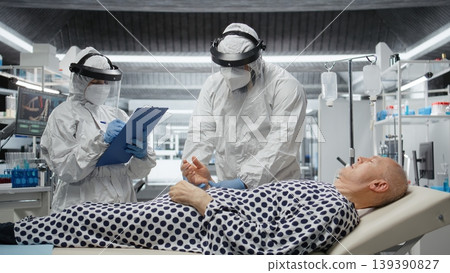 Doctors team in full protective gear analyzes infected patient during pandemic, studying bacteria and managing contamination control. Vaccine development to prevent global disaster. Camera A. Doctors team in full protective gear analyzes infected patient during pandemic, studying bacteria and managing contamination control. Vaccine development to prevent global disaster. Camera A. 139390827