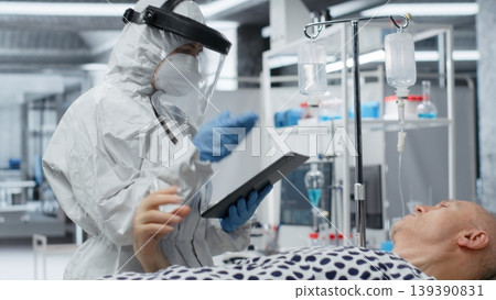 Researcher in protective gear works in biohazard zone to treat a contagious patient, analyzing infection data to advance immunology and epidemic prevention in biotechnology research. Camera B. Researcher in protective gear works in biohazard zone to treat a contagious patient, analyzing infection data to advance immunology and epidemic prevention in biotechnology research. Camera B. 139390831