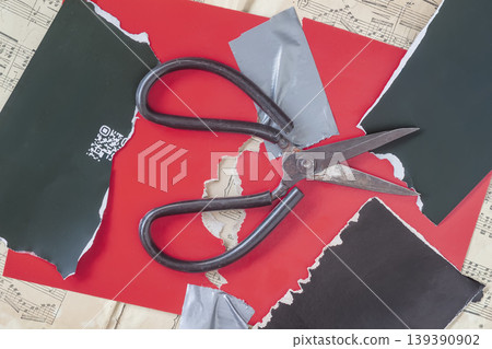 Top view of Scissors lie on torn paper scraps, tape strips, sheet music, and graphic collage surface. Natural background of craft, design, paper art, collage, DIY project Top view of Scissors lie on torn paper scraps, tape strips, sheet music, and graphic collage surface. Natural background of craft, design, paper art, collage, DIY project 139390902