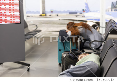 Worried passengers after announcement of all flights cancelled, with travelers reacting in panic and frustration. Terminal with grounded airplanes, postponed departures highlights travel disruption. Worried passengers after announcement of all flights cancelled, with travelers reacting in panic and frustration. Terminal with grounded airplanes, postponed departures highlights travel disruption. 139390912