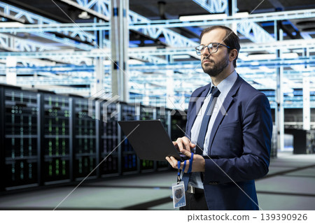 Managing enterprise, laptop and software developer in data center, technology solutions. Supervising operations, notebook application and IT specialist in futuristic server room Managing enterprise, laptop and software developer in data center, technology solutions. Supervising operations, notebook application and IT specialist in futuristic server room 139390926