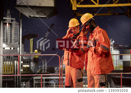 Offshore diverse workers monitoring drilling rig systems and activity with devices, managing natural gas and petroleum extraction from industrial platform. Oil and gas production for industry. Offshore diverse workers monitoring drilling rig systems and activity with devices, managing natural gas and petroleum extraction from industrial platform. Oil and gas production for industry. 139391058