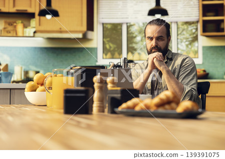Focused freelancer does nervous tic and cracking knuckles at laptop, working remotely in the kitchen with involuntary movements and nervous habit. Popping sounds from fingers. Focused freelancer does nervous tic and cracking knuckles at laptop, working remotely in the kitchen with involuntary movements and nervous habit. Popping sounds from fingers. 139391075