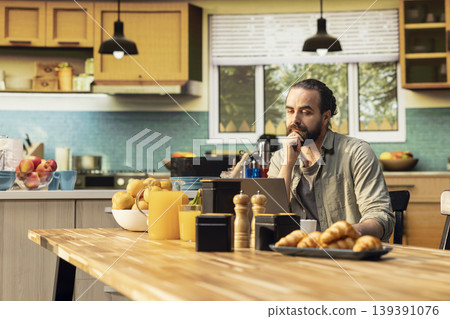Hopeless overworked man demotivated with burnout and low energy, monotonous slow workday at home. Dejected freelancer bored with his occupation, telecommuting discontent. 139391076