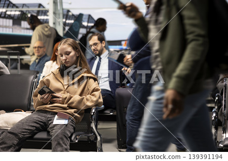 Using phone, airport lounge and woman looking at plane departure timetable online. Planning tourism activities, smartphone and girl doing travel destination itinerary during flight layover Using phone, airport lounge and woman looking at plane departure timetable online. Planning tourism activities, smartphone and girl doing travel destination itinerary during flight layover 139391194