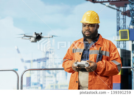 Drilling rig technician using drone gadget for quick overview and evaluation of hard to reach areas. Man working on offshore ship uses remote control UAV for preventive maintenance planning Drilling rig technician using drone gadget for quick overview and evaluation of hard to reach areas. Man working on offshore ship uses remote control UAV for preventive maintenance planning 139391259