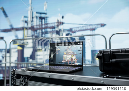 Close up of laptop on offshore platform with software interface used to track production efficiency. Notebook on drilling barge deck with program dashboard used to check equipment sensor readings 139391318