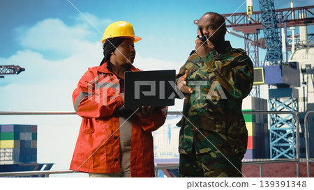 Soldier working on offshore platform communicating via military radio. Naval unit boarding drilling barge under maritime interdiction protocol, speaking on tactical walkie talkie, Soldier working on offshore platform communicating via military radio. Naval unit boarding drilling barge under maritime interdiction protocol, speaking on tactical walkie talkie, 139391348