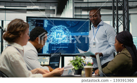 Programmer gives presentation to executives, implementing AI chatbot reducing work volume. Startup office IT expert analyzing business insights for management using artificial intelligence, camera B Programmer gives presentation to executives, implementing AI chatbot reducing work volume. Startup office IT expert analyzing business insights for management using artificial intelligence, camera B 139391360