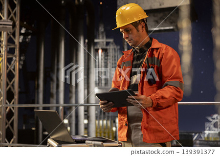Professional rig worker on drilling platform inspecting emission systems under northern lights, ensuring compliance and responsible petroleum extraction in marine environments. 139391377