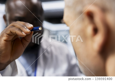Close up of black man scientist conducting tests on a senior man in research lab, observing side effects and allergic reactions. Scientist testing drug on patient to launch safe treatment. Close up of black man scientist conducting tests on a senior man in research lab, observing side effects and allergic reactions. Scientist testing drug on patient to launch safe treatment. 139391400
