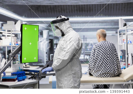 Vertical green screen next to black medic in hazmat suit observing contagious epidemic in lab, examining patient with serious symptoms. Preventing global disaster and health crisis. Vertical green screen next to black medic in hazmat suit observing contagious epidemic in lab, examining patient with serious symptoms. Preventing global disaster and health crisis. 139391443