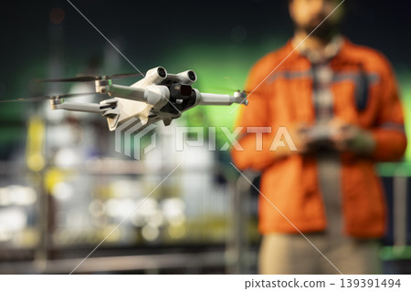 Close up of drone used by technician to inspect integrity of offshore platform late at night. Drilling rig crew member using aerial photography to do equipment maintenance 139391494