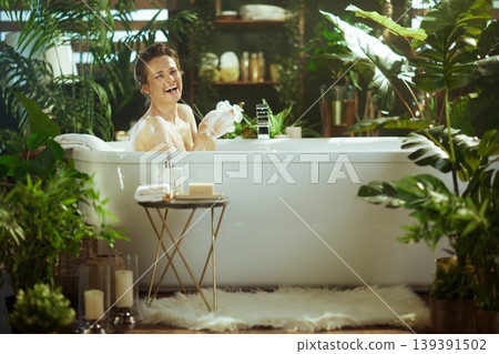 Happy Woman Enjoying a Bright Bubble Bath at Home Happy Woman Enjoying a Bright Bubble Bath at Home 139391502