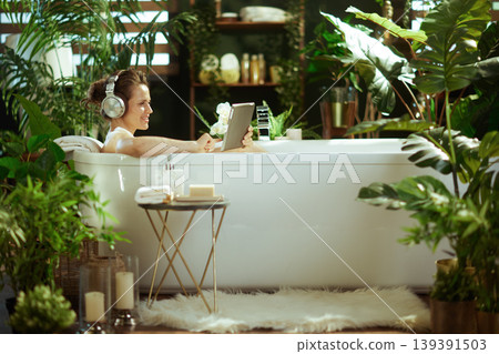 Woman with Headphones Enjoying Spa Bath & Tablet Woman with Headphones Enjoying Spa Bath & Tablet 139391503