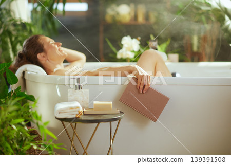 Calm Woman Enjoying a Book in a Plant-Filled Bath Calm Woman Enjoying a Book in a Plant-Filled Bath 139391508