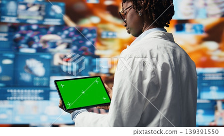 Close up of mockup tablet used by healthcare expert looking at CT scans and lab analytics on videowall. Scientist in medical research lab reading health data with isolated screen device, camera A Close up of mockup tablet used by healthcare expert looking at CT scans and lab analytics on videowall. Scientist in medical research lab reading health data with isolated screen device, camera A 139391550