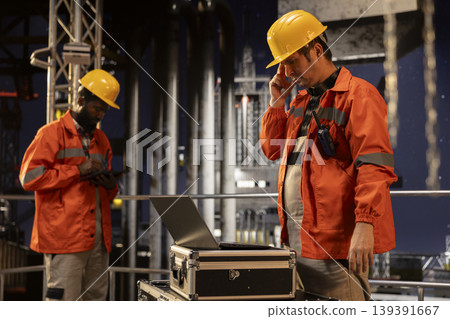 Pensive focused environmental officer on offshore drilling platform writing carbon footprint data on a clipboard, ensuring compliance and efficient petroleum extraction from the ocean. 139391667