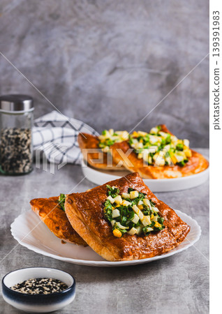 Appetizing puff pastries with boiled egg and green onions on a plate on the table vertical view 139391983