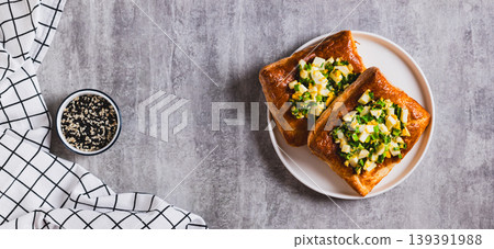 Mini puff pastry tarts with egg and green onions on a plate on the table top view web banner Mini puff pastry tarts with egg and green onions on a plate on the table top view web banner 139391988