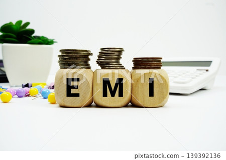Stack of coins with wood blocks with "EMI (Equated Monthly Installment)" Financial concept Stack of coins with wood blocks with "EMI (Equated Monthly Installment)" Financial concept 139392136