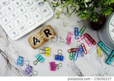 AR Accounts Receivable alphabet letters with calculator and alarm clock on marble background 139392217