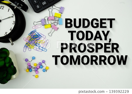 Budget Today, Prosper Tomorrow message with calculator, alarm clock and Stationery on white background Budget Today, Prosper Tomorrow message with calculator, alarm clock and Stationery on white background 139392229
